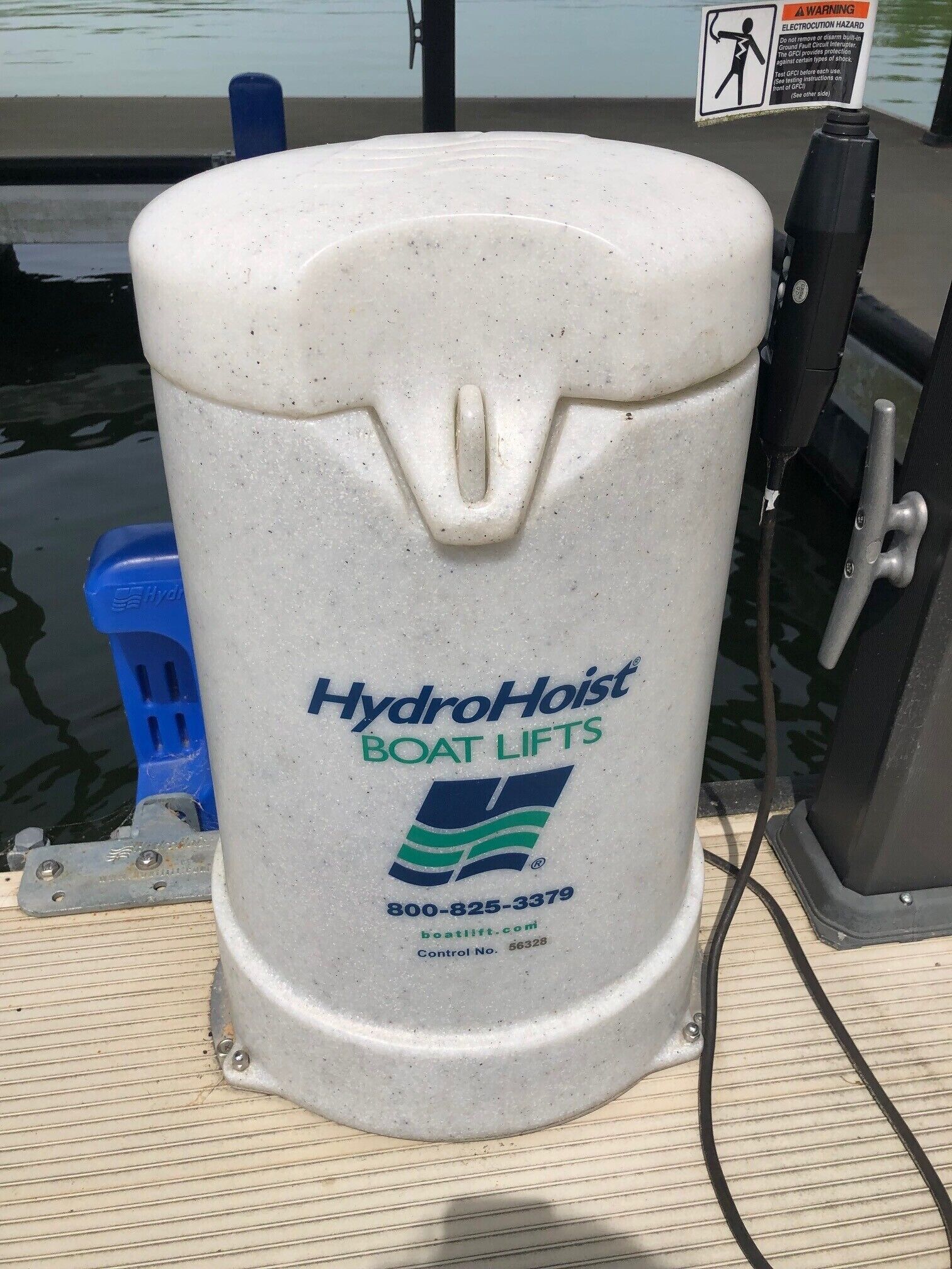 Un conteneur blanc, à surface texturée, portant l’inscription « HydroHoist Boat Lifts », ainsi qu’un logo, un numéro de téléphone et l’adresse d’un site web.