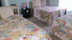 Une chambre avec deux lits, une table de chevet et une lampe.