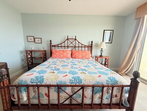 A bed with a wooden frame and a floral-patterned bedspread.