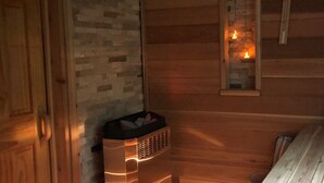 L’intérieur d’un chalet accueillant, avec un mur en pierre, une porte en bois, une petite fenêtre illuminée par une bougie et un banc en bois.