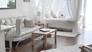 Une chambre à coucher moderne avec un lit, un canapé, une petite table et une chaise.