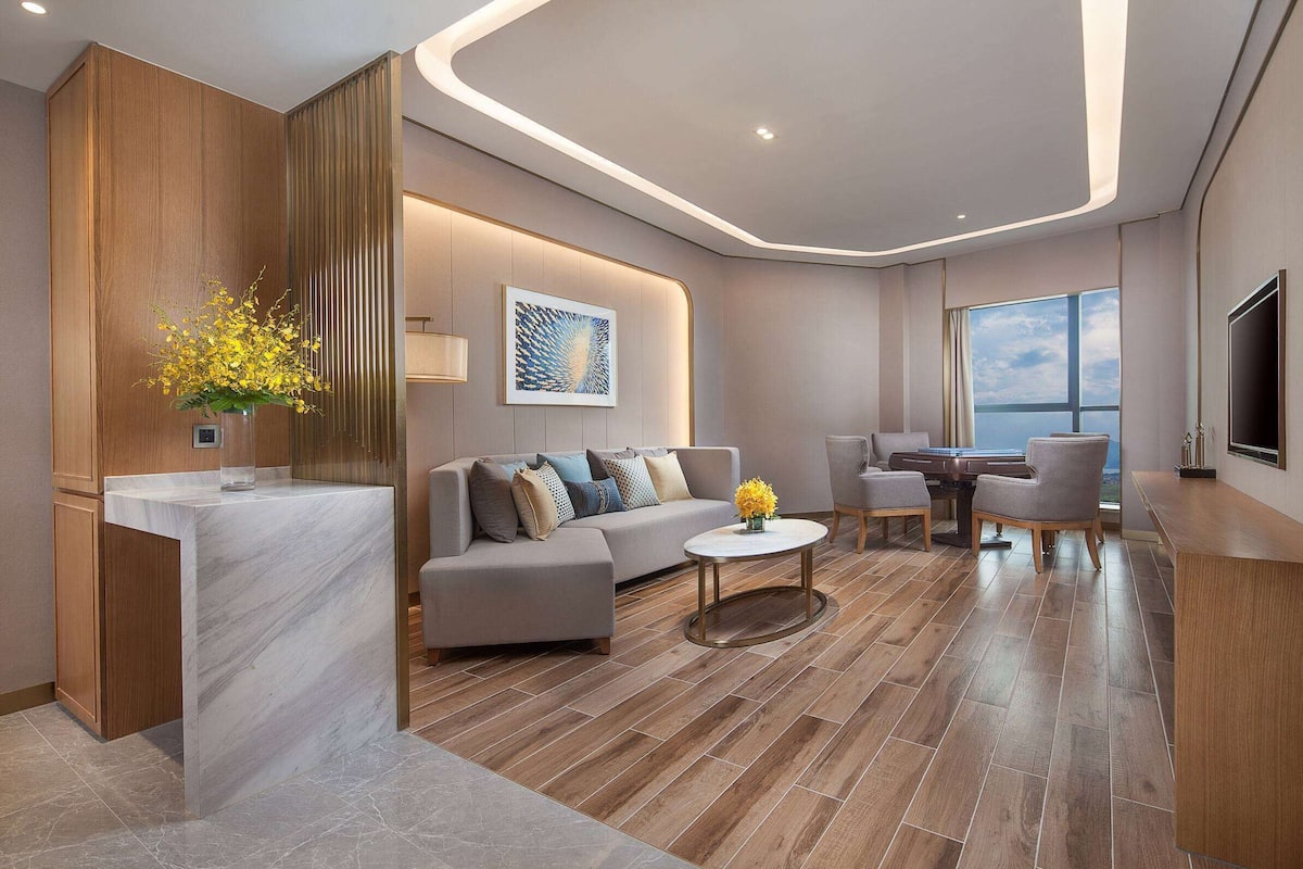 Een moderne woonkamer met een marmeren eiland, een bank en een eethoek.