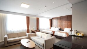 A modern hotel room with a sofa, two single beds, a dining table, and a kitchen area. - Gangneung City Hotel (Gangneung)