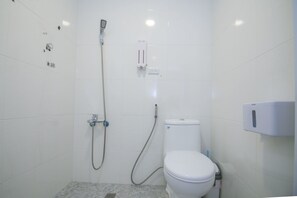 A small, white bathroom with a toilet, a shower, and a soap dispenser. - Garden House 152 (Tainan)