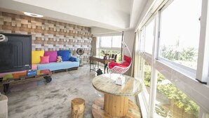 A modern living room with a sofa, a hanging chair, a table, and a TV.