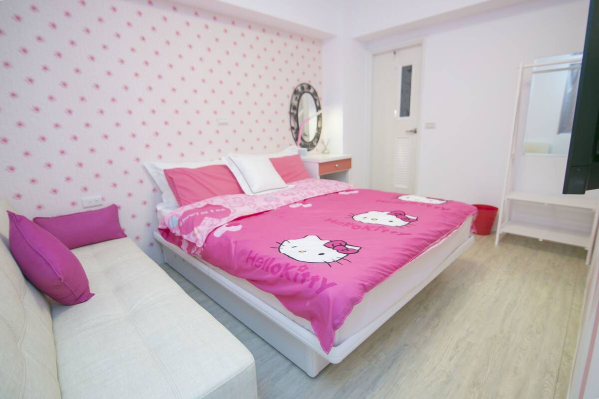 A bedroom with a bed, a nightstand, a mirror, and a dresser.