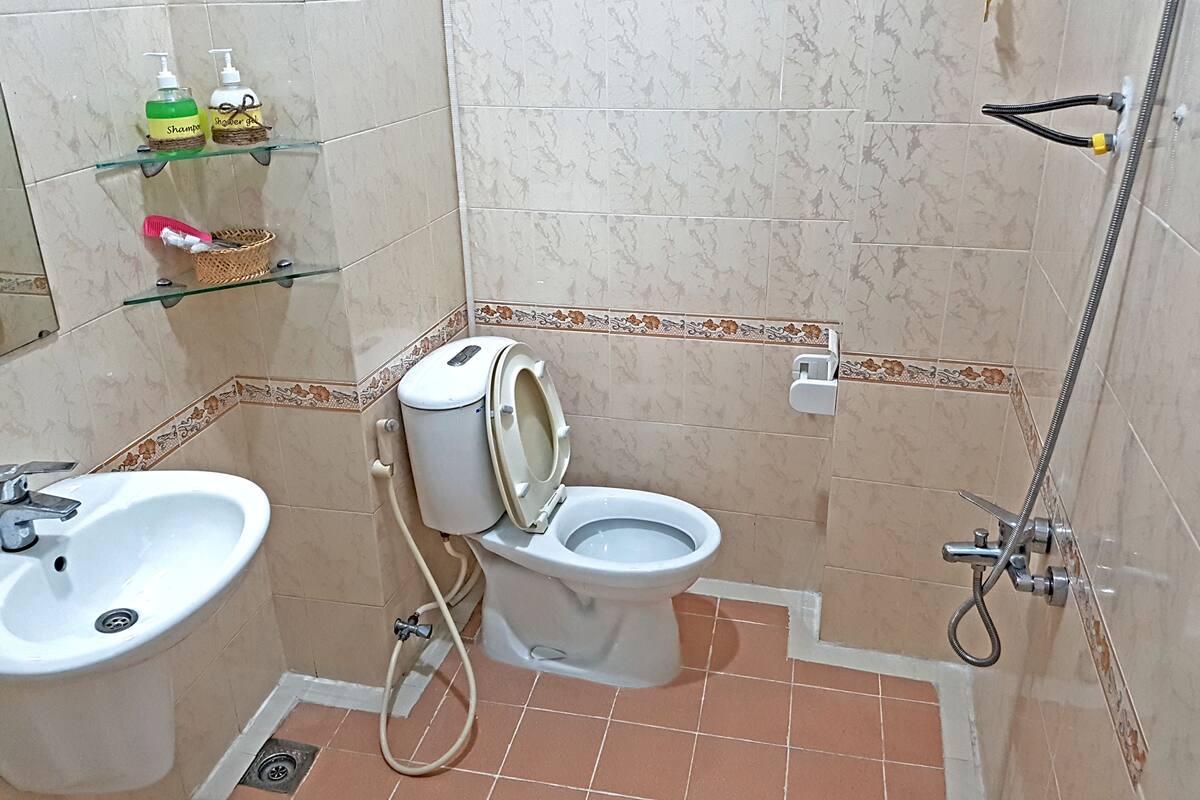 A bathroom with a toilet, bidet, sink, and shower.