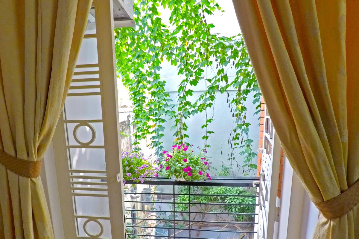 An open balcony with a view of a garden.