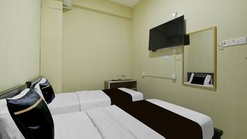 A hotel room with two beds, a TV mounted on the wall, a bedside table, and a mirror.