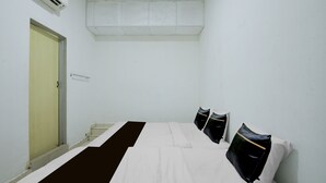 Una habitación con cama, puerta y ventana.