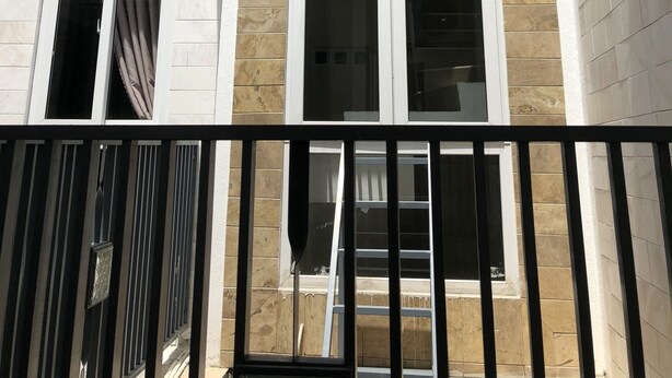 A multi-story building with large windows and a balcony. - Homestay Des Amis - Ban Huu (Da Nang)