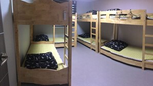 A dormitory room with bunk beds, each with a pillow and a blanket. - JJBro Hostel Guest House (Mokpo)