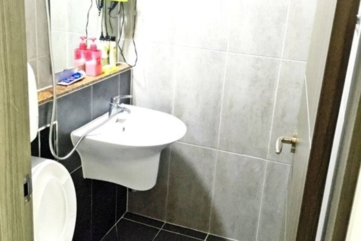 Une petite salle de bain avec un lavabo blanc, un miroir et des toilettes.