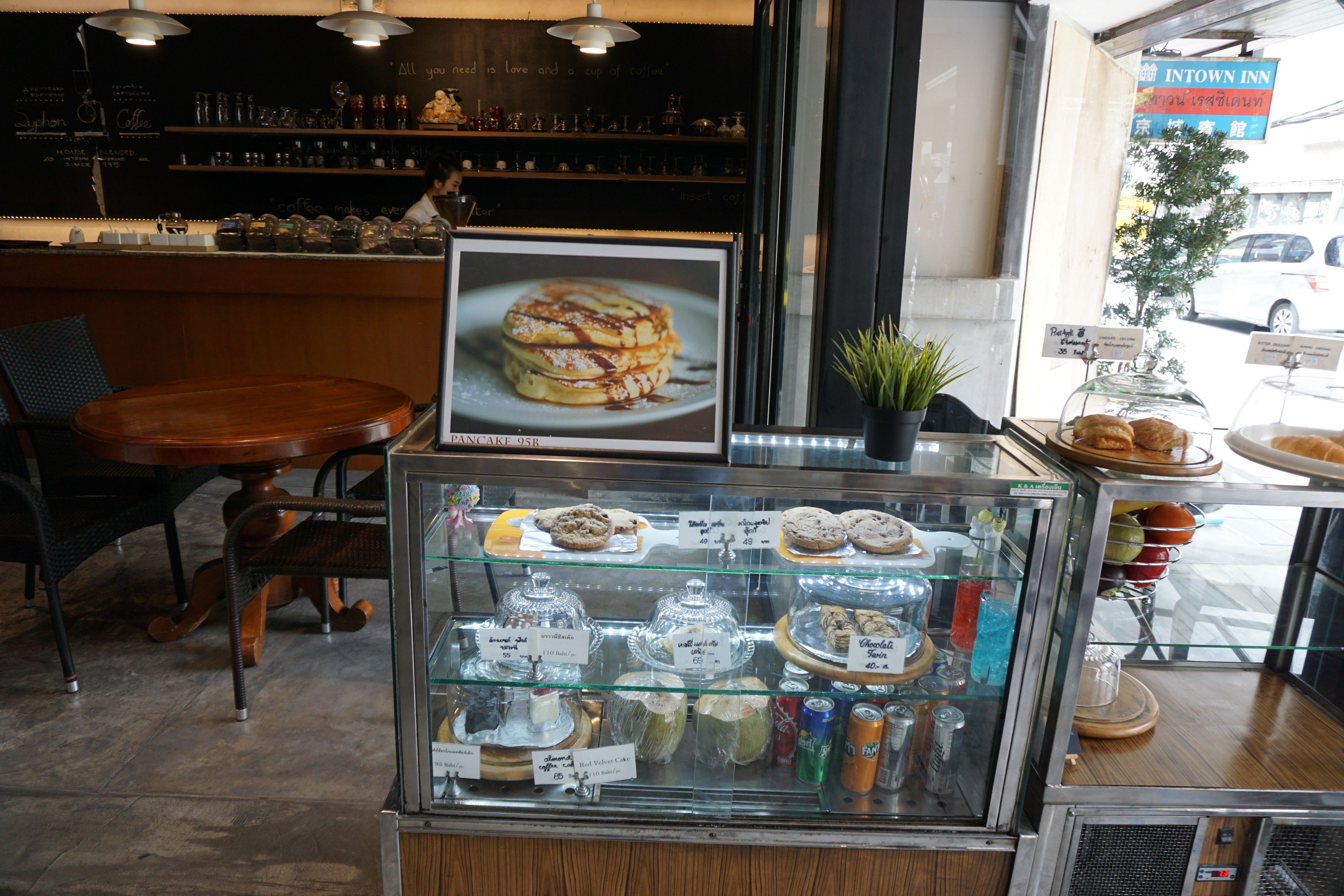 Une vitrine de boulangerie présentant diverses pâtisseries et une pancarte indiquant le prix d’une crêpe, soit 95 B.