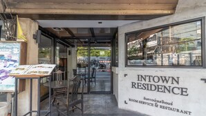 Um restaurante com uma placa que diz "INTOWN RESIDENCE ROOM SERVICE & RESTAURANT".