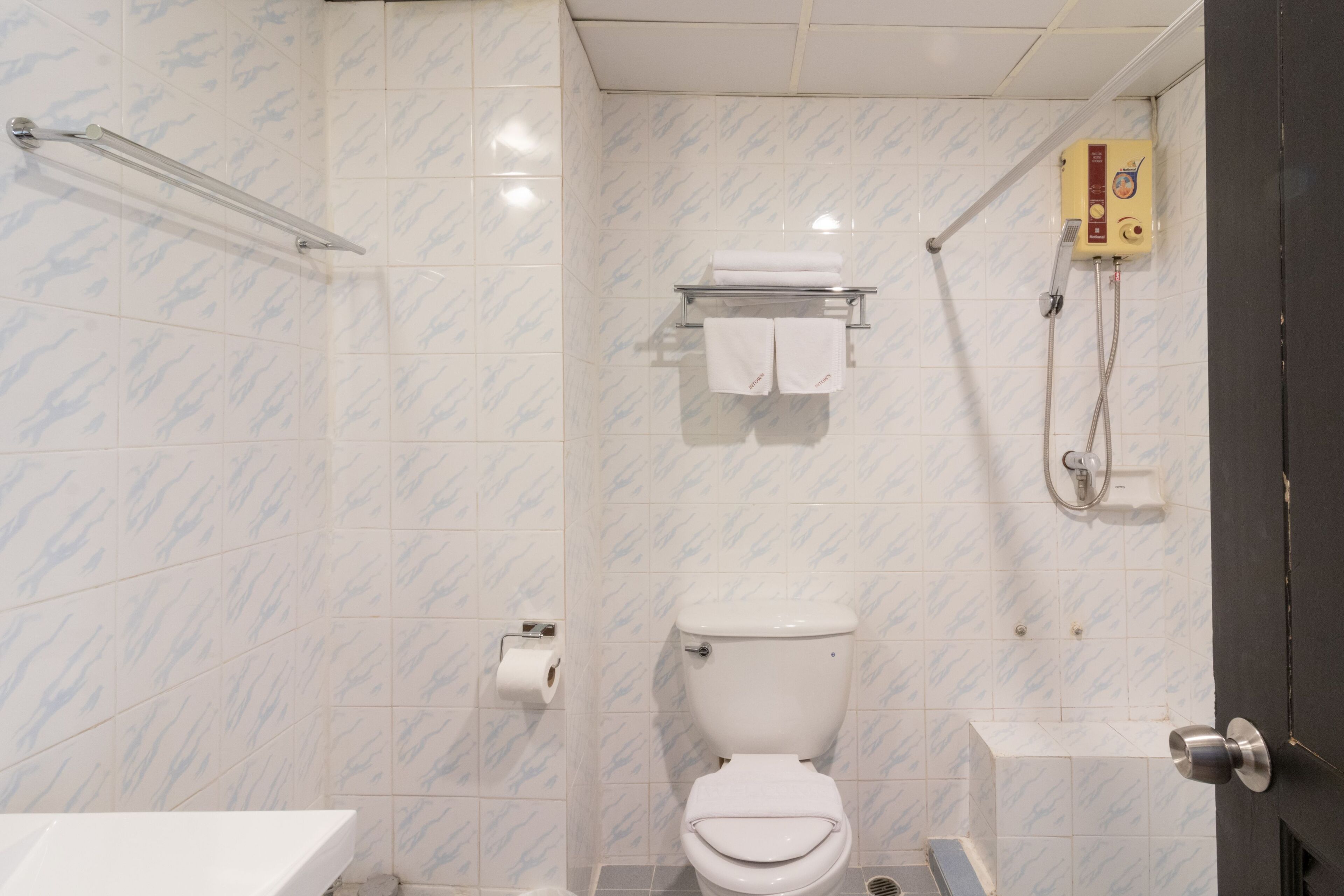 Ein Badezimmer mit Toilette, Dusche und Handtuchhalter.