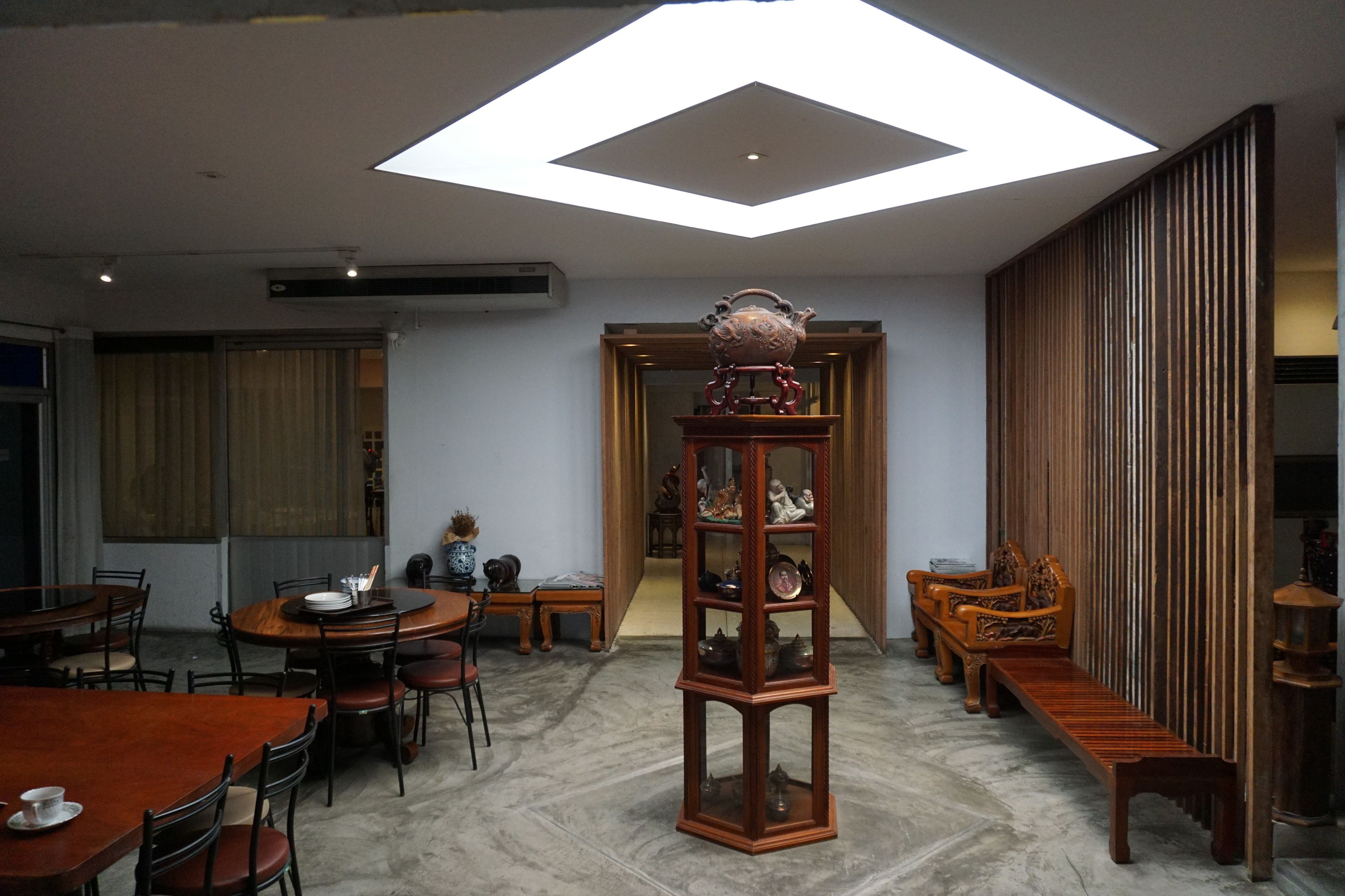 Un intérieur moderne comprenant un coin repas, une bibliothèque en bois et une vue sur l’extérieur, visible à travers une porte.