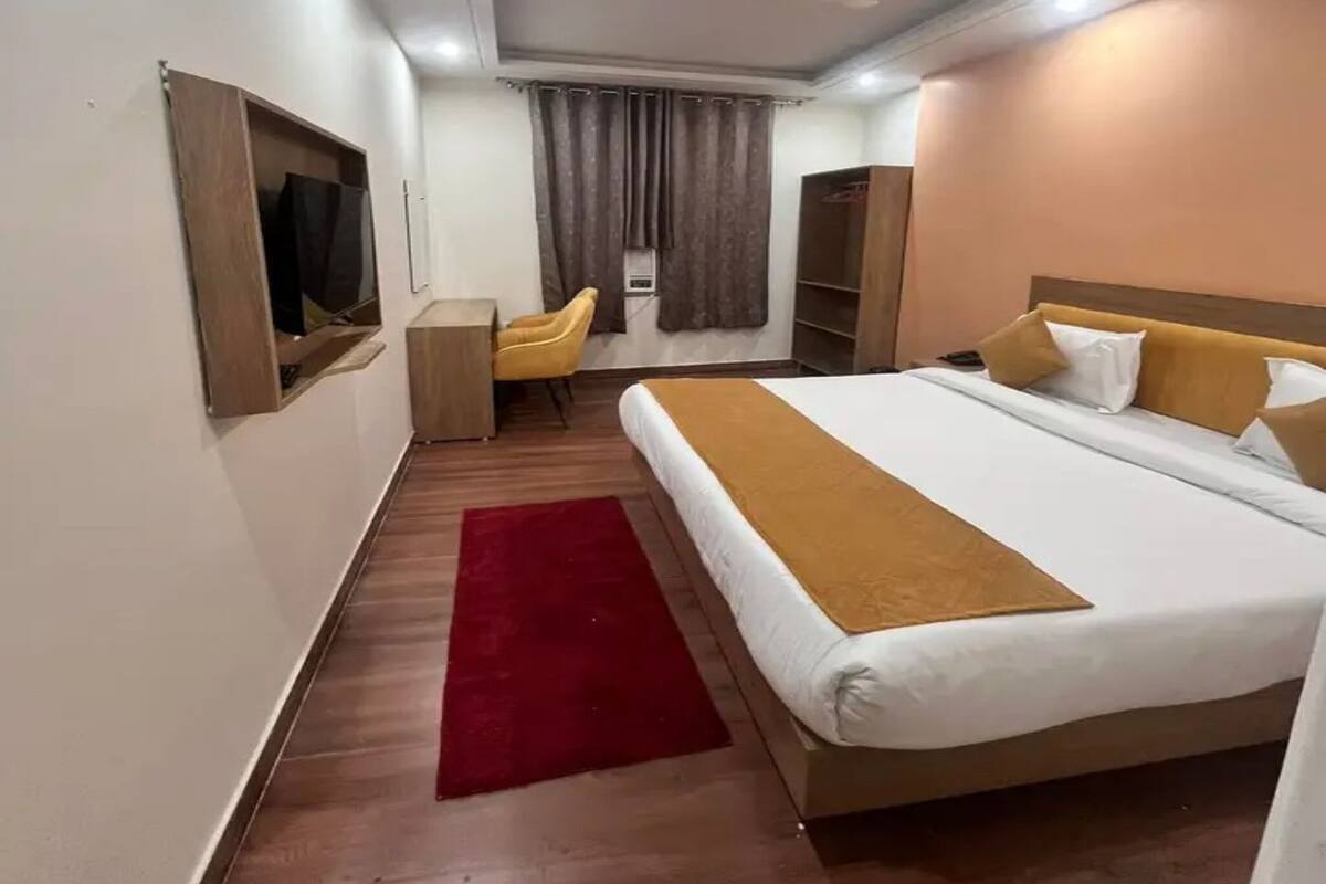Een hotelkamer met een bed, een bureau, een stoel en een kledingkast.