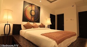A 3-bedroom hotel room with a large bed, two bedside lamps, a decorative wall piece, and a patterned rug. - Villas Aelita Pool Villa Resort (Choeng Thale)