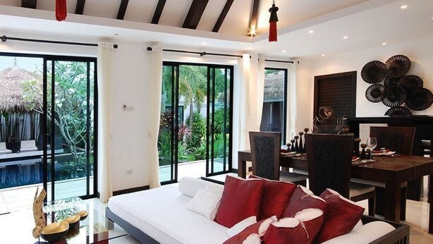 Habitación de hotel moderna con una cama grande, zona de comedor y vistas al exterior.