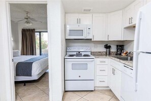 A compact kitchen with a microwave, stove, and refrigerator.