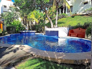 Een buitenzwembad en ligstoelen