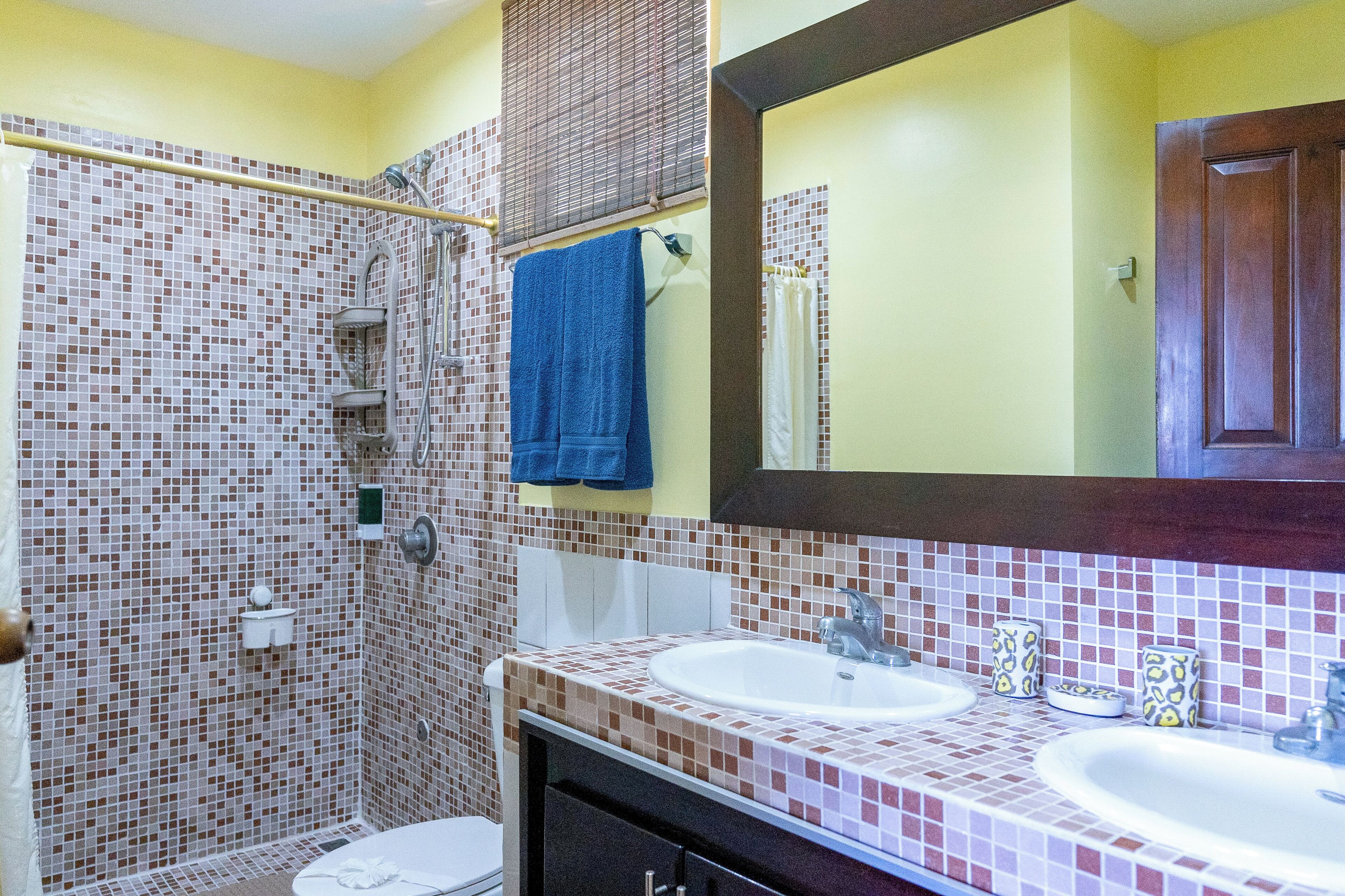 Une salle de bain avec deux lavabos, une douche et des toilettes.