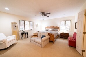 A bedroom with a bed, a chair, a dresser, and a ceiling fan. - We weathered Helene beautifully!      Welcome to your new, lovely mountain home! (Asheville)