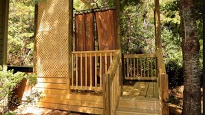 A wooden deck with a staircase leading to a covered area, surrounded by trees. - We weathered Helene beautifully!      Welcome to your new, lovely mountain home! (Asheville)