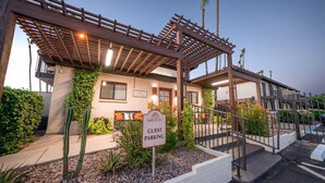 A guest parking area with a sign indicating 'Guest Parking' at a hotel with a covered entrance and outdoor seating area.