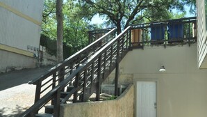 Eine Betontreppe mit Metallgeländer führt zu einer Tür.
