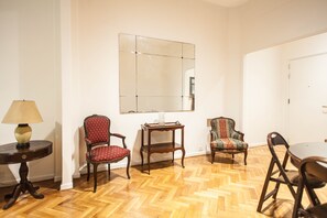 Relax in a stylish room with a large mirror, round table, and comfortable seating.