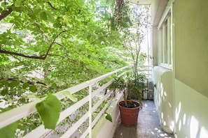 Enjoy the serene views of lush greenery from this balcony.