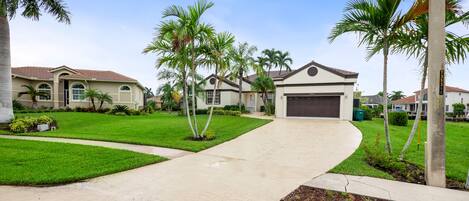 A residential area with a curved driveway leading to a house with a garage.