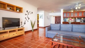 Ein Wohnzimmer mit Fernseher, Sofa und Couchtisch.