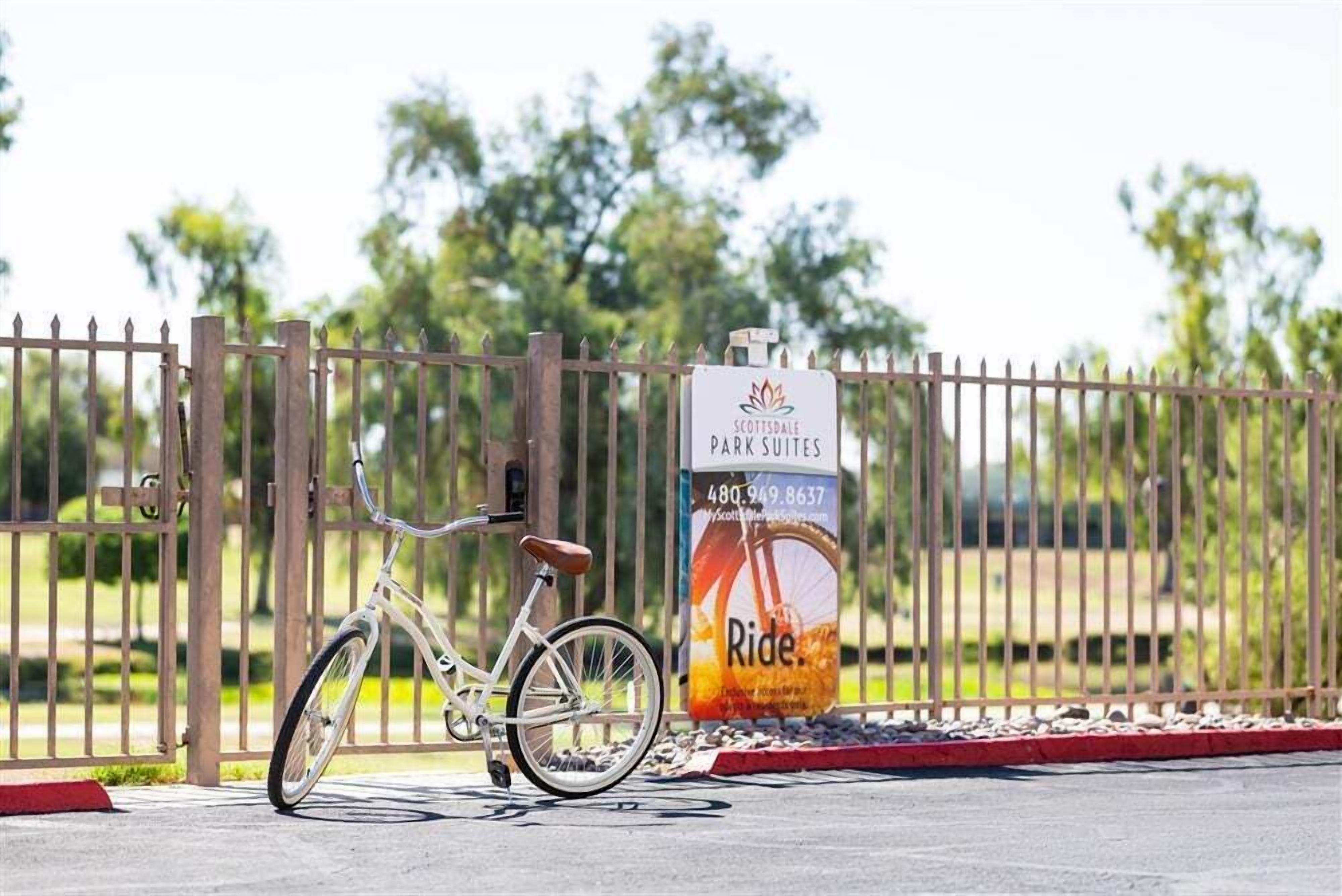 Un vélo est garé à côté d’une porte sur laquelle est apposée une enseigne indiquant « Scottsdale Park Suites ».