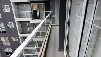 Ein modernes Gebäude mit Glasgeländer, gefliestem Boden und einem großen Fenster.