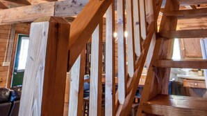 Una escalera de madera con barandilla que lleva a un nivel superior.
