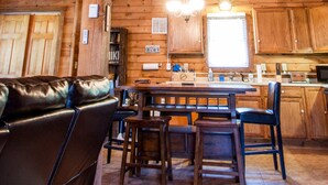 Un interior rústico de madera con comedor, cocina y zona de estar.