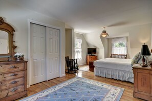 Un dormitorio con cama, cómoda y un espejo grande.