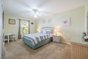 A bedroom with a bed, a desk, a chair, a ceiling fan, and a window with curtains. - Beautiful Waterfront Property, Direct Gulf Access, Saltwater Heated Pool & Spa (Cape Coral)