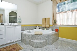 A bathroom with a freestanding bathtub, a sink, and a mirror.