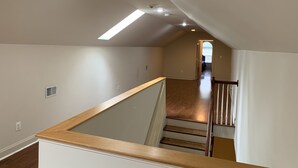 A spacious room with a wooden staircase leading to an upper level. - Nice Quiet Family Home - Long Term (Potomac)