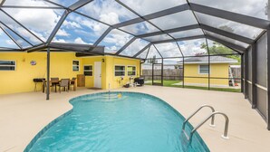 An indoor swimming pool with a glass ceiling, yellow walls, and a patio area with outdoor seating. - Downtown home, sleeps 6, pool, free WiFi, walk to Library, Doc's, Eatery (Port Charlotte)