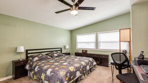 A bedroom with a bed, a desk, a chair, a ceiling fan, and a window with blinds. - Downtown home, sleeps 6, pool, free WiFi, walk to Library, Doc's, Eatery (Port Charlotte)