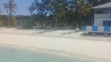 En la playa, camastros, toallas de playa y bar en la playa