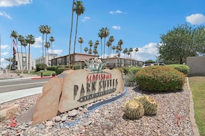 Scottsdale Park Suites sign, palm trees, and a cactus.