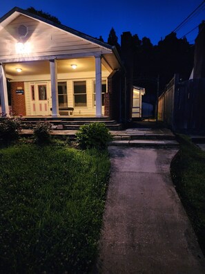 A building with a porch, a door, and a window.