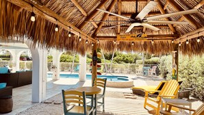Un espace extérieur abrité comprenant une piscine, une terrasse en bois et des chaises longues.