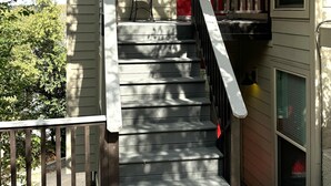 A staircase leading to a red door with a heart decoration, a small table, and a chair on the landing. - View, 1 King bed & sleeper; .33 mi to Barton Springs/Zilker Park, @2 mi to DT! (Austin)